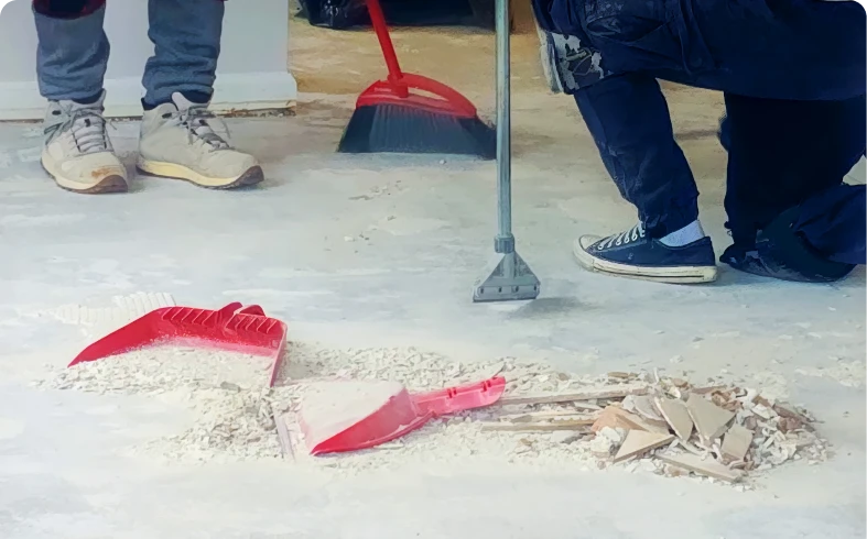 Workers sweeping debris on floor